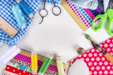 Dikiş dikme, dikiş ve giysi onarımı, arka plan, koleksiyon defteri, yorgan dikme. Renkli kumaş, makas, cetvel, dikiş araçları, iğneler, iplikler beyaz masa arkaplanındaki üst görünüm kopyalama alanı