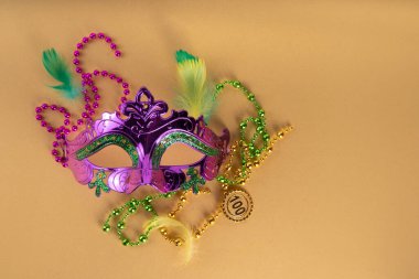 Mardi Gras renkli bayram tebrik kartı arkaplanı festival maskesi, dekor, karnaval maskesi, boncuklar, tüyler, parlak arka plandaki fanlar geleneksel mor yeşil renkler