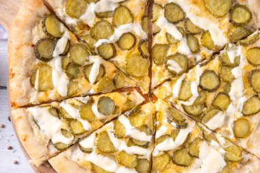 Peynir soslu turşulu pizza ve salatalık turşusu. Moda Asya tarzı, vejetaryen ekşi pizza, mutfak masasında fotokopi alanı.