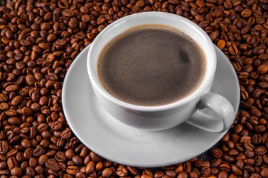 Kruvasan ve kahve çekirdekli sade espresso kahve fincanı, basit geleneksel Fransız kahvaltısı.