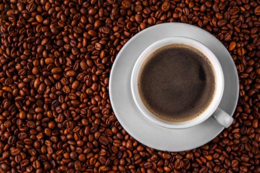 Kruvasan ve kahve çekirdekli sade espresso kahve fincanı, basit geleneksel Fransız kahvaltısı.