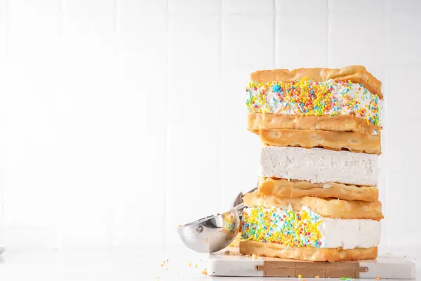Waffle ice cream sandwiches. Tasty ice cream with fluffy belgian waffles and sugar sprinkles, Summer delicious tasty dessert, on white background with ice cream spoon