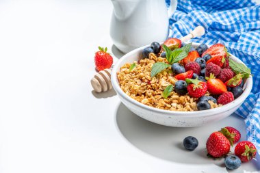 Healthy breakfast granola with fresh berry - strawberry, raspberry, blueberry on white background