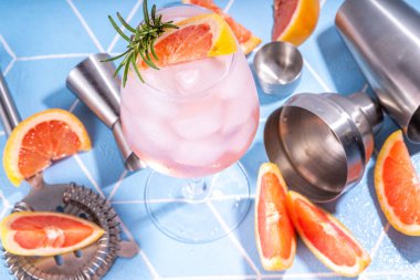 Yaz alkolü greyfurt ve biberiyeli ferahlatıcı içecek. Greyfurt margarita veya mimoza kokteyli. Yaz güneşinde alkolsüz narenciye moktail. Mavi arkaplan fotokopi alanı.