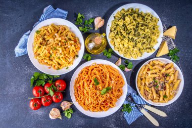 Beyaz fayanslı arka planda farklı soslu makarna seti. Spagetti, farfalle, makarna, deniz ürünleri, ıspanak, karbonara, domates soslu fusilli makarna. İtalyan yemeği, Akdeniz yemeği konsepti