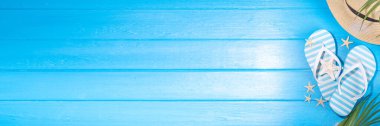 Bright sunny lighted summer vacation background, vacation and travel, beach accessories, swim suit, hat, flip flops, photo camera, sea star and shells on high-colored blue wooden background top view