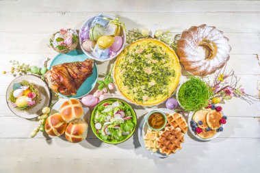 Bayram yemeği, Paskalya brunch 'ı. Geleneksel Paskalya yemekleri aile sofrasında - pişmiş et, kiş, bahar salatası, kek, renkli yumurta, sıcak haç çörekleri