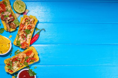 Traditional Mexican street food, fast food background, corn Taco, nachos with meat, vegetables, avocado, beans, corn, salsa. Served with various sauces. Mexican holiday flatlay