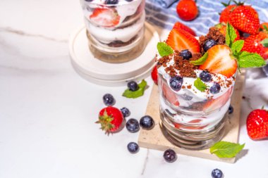 Çilekli tatlı, katmanlı parfe tatlı çikolatalı bisküvi, çırpılmış krema ve taze böğürtlen. Bardakta yaz kahvaltısı tatlısı