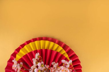 Kopya alanı olan Çin Yeni Yıl temalı arka plan. Kırmızı fanlar, altın sikkeler, mandallar, kiraz çiçekleri, bayram altın dalları, dekorlar, dilek zarfları. Altın arka planda altın ejder 