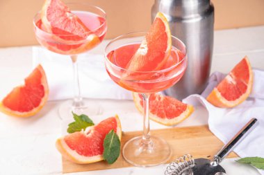 Soğuk şampanyalı greyfurt martini kokteyli. Yaz kokteylini, bir parça greyfurt ve nane şekeriyle bar aletleri ve malzemeleriyle tazeliyorum.