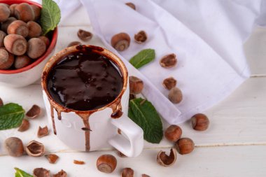 Beyaz fındıklı fındıklı sıcak çikolata, beyaz ahşap arka planda fındıklı, kopyalama alanı