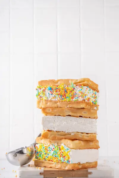 Waffle ice cream sandwiches. Tasty ice cream with fluffy belgian waffles and sugar sprinkles, Summer delicious tasty dessert, on white background with ice cream spoon