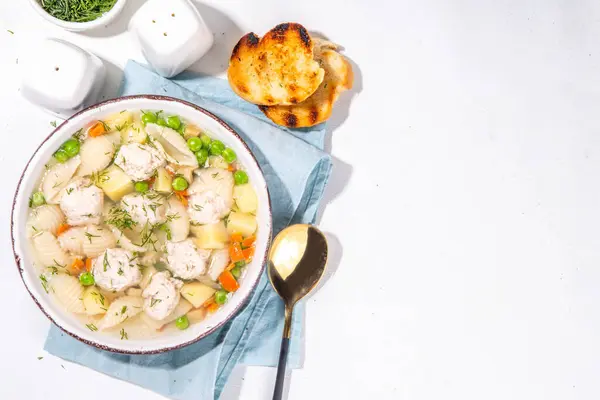 Homemade soup with chicken and turkey meatballs, shell Conchiglie pasta and vegetables, with greens. White meat broth with vegetables and macaroni, healthy diet food, children\'s lunch