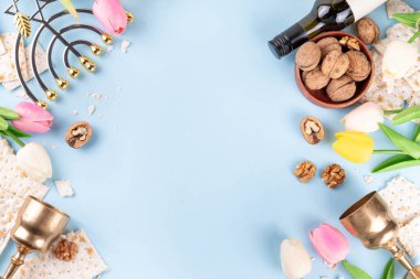 Hamursuz Bayramı geçmişi. Geleneksel Yahudi ekmek matzası, kırmızı koşer şarabı, ceviz, bahar güzel çiçekleri. Yahudi Paskalya Pesah bahar tatili arka plan kopya alanı