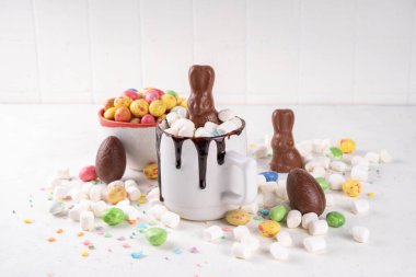 Çikolatalı ve tavşanlı Paskalya tatlı sıcak çikolata kupası, Paskalya sembollü ev yapımı kakao tarifi çikolatalar ve marşmelov, beyaz mutfak arka planı kopyalama alanı.