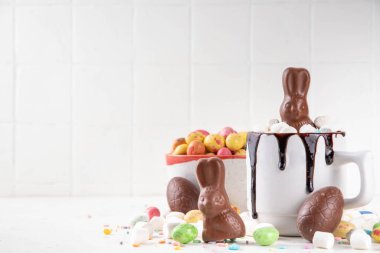 Çikolatalı ve tavşanlı Paskalya tatlı sıcak çikolata kupası, Paskalya sembollü ev yapımı kakao tarifi çikolatalar ve marşmelov, beyaz mutfak arka planı kopyalama alanı.