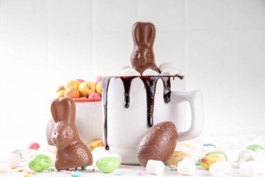 Çikolatalı ve tavşanlı Paskalya tatlı sıcak çikolata kupası, Paskalya sembollü ev yapımı kakao tarifi çikolatalar ve marşmelov, beyaz mutfak arka planı kopyalama alanı.