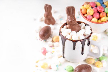 Çikolatalı ve tavşanlı Paskalya tatlı sıcak çikolata kupası, Paskalya sembollü ev yapımı kakao tarifi çikolatalar ve marşmelov, beyaz mutfak arka planı kopyalama alanı.