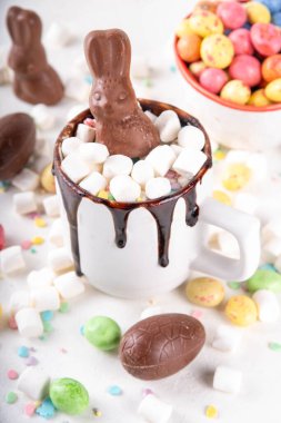 Çikolatalı ve tavşanlı Paskalya tatlı sıcak çikolata kupası, Paskalya sembollü ev yapımı kakao tarifi çikolatalar ve marşmelov, beyaz mutfak arka planı kopyalama alanı.
