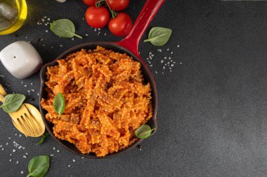 Domates soslu Mafaldine makarnası, İtalyan bolonezi, domates soslu marinara, vegan mantarı ya da siyah beton arka planda patlıcan soslu makarna, malzemeler ve baharatlar, kopyalama alanı.