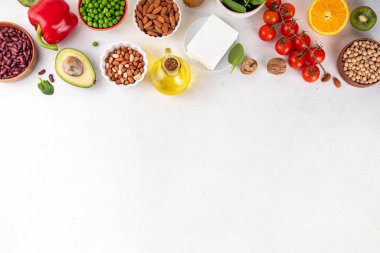 Portföy diyeti, fındık, sebze proteini, bitki sterolleri, yapışkan lif, fasulye, baklagiller, taze sebzeler ve beyaz arka plandaki meyveler dahil olmak üzere dengeli kolesterol vejetaryen gıdalar.