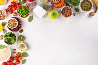 Portföy diyeti, fındık, sebze proteini, bitki sterolleri, yapışkan lif, fasulye, baklagiller, taze sebzeler ve beyaz arka plandaki meyveler dahil olmak üzere dengeli kolesterol vejetaryen gıdalar.