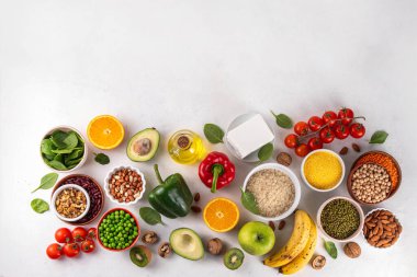 Portföy diyeti, fındık, sebze proteini, bitki sterolleri, yapışkan lif, fasulye, baklagiller, taze sebzeler ve beyaz arka plandaki meyveler dahil olmak üzere dengeli kolesterol vejetaryen gıdalar.