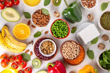 Portföy diyeti, fındık, sebze proteini, bitki sterolleri, yapışkan lif, fasulye, baklagiller, taze sebzeler ve beyaz arka plandaki meyveler dahil olmak üzere dengeli kolesterol vejetaryen gıdalar.