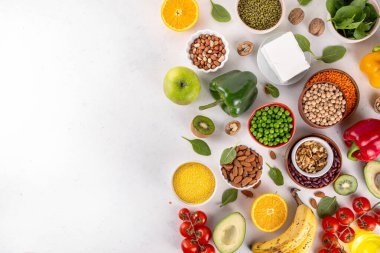 Portföy diyeti, fındık, sebze proteini, bitki sterolleri, yapışkan lif, fasulye, baklagiller, taze sebzeler ve beyaz arka plandaki meyveler dahil olmak üzere dengeli kolesterol vejetaryen gıdalar.