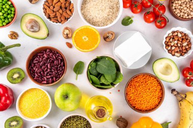 Portföy diyeti, fındık, sebze proteini, bitki sterolleri, yapışkan lif, fasulye, baklagiller, taze sebzeler ve beyaz arka plandaki meyveler dahil olmak üzere dengeli kolesterol vejetaryen gıdalar.