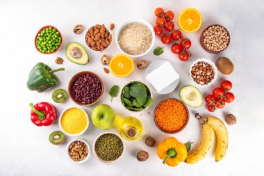 Portföy diyeti, fındık, sebze proteini, bitki sterolleri, yapışkan lif, fasulye, baklagiller, taze sebzeler ve beyaz arka plandaki meyveler dahil olmak üzere dengeli kolesterol vejetaryen gıdalar.