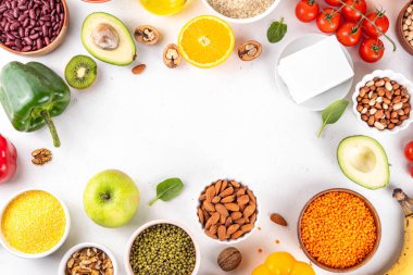 Portföy diyeti, fındık, sebze proteini, bitki sterolleri, yapışkan lif, fasulye, baklagiller, taze sebzeler ve beyaz arka plandaki meyveler dahil olmak üzere dengeli kolesterol vejetaryen gıdalar.