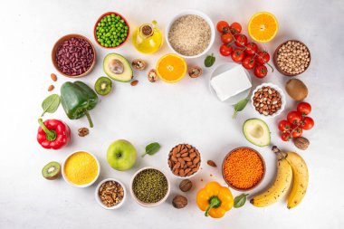 Portföy diyeti, fındık, sebze proteini, bitki sterolleri, yapışkan lif, fasulye, baklagiller, taze sebzeler ve beyaz arka plandaki meyveler dahil olmak üzere dengeli kolesterol vejetaryen gıdalar.