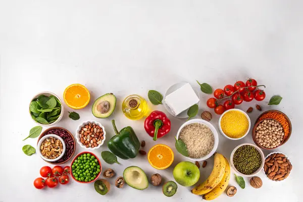 Portföy diyeti, fındık, sebze proteini, bitki sterolleri, yapışkan lif, fasulye, baklagiller, taze sebzeler ve beyaz arka plandaki meyveler dahil olmak üzere dengeli kolesterol vejetaryen gıdalar.