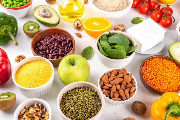 Portföy diyeti, fındık, sebze proteini, bitki sterolleri, yapışkan lif, fasulye, baklagiller, taze sebzeler ve beyaz arka plandaki meyveler dahil olmak üzere dengeli kolesterol vejetaryen gıdalar.