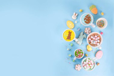 Paskalya partisi, kahvaltı, öğle yemeği için sıcak tatlı içecekler. Paskalya menüsü. Pembe, sarı, mavi, kahverengi, lokum kaplı sıcak çikolata bardakları, çikolatalı tavşan, latte yüzeyinde paskalya yumurtaları.