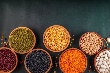 Çeşitli kuru fasulyeler, mercimek, mung, nohut, ahşap kaselerde bezelye çeşitleri. Legumes beyaz masa üst görünümünde. Vegan protein kaynakları yiyecek, kopyalama alanı