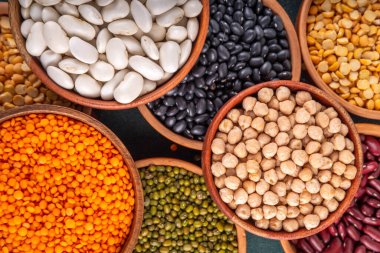 Çeşitli kuru fasulyeler, mercimek, mung, nohut, ahşap kaselerde bezelye çeşitleri. Legumes beyaz masa üst görünümünde. Vegan protein kaynakları yiyecek, kopyalama alanı
