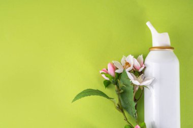 Mevsimlik bahar alerjisi konsepti. Taze bahar çiçek açan ağaç dalları, çeşitli burun alerjisi tedavileri, damlalar, alerji için sprey şişeleri, rhinitis, pollinosi, renkli arkaplanda kopyalama alanı