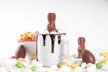 Çikolatalı ve tavşanlı Paskalya tatlı sıcak çikolata kupası, Paskalya sembollü ev yapımı kakao tarifi çikolatalar ve marşmelov, beyaz mutfak arka planı kopyalama alanı.