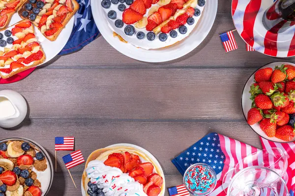 Fourth of July, Patriotic Independence day desserts.  4th of July sweet brunch food and snacks - toast sandwiches, flakes with berries, cake, pancakes, champagne with glasses, holiday decor, flags