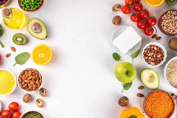 Portföy diyeti, fındık, sebze proteini, bitki sterolleri, yapışkan lif, fasulye, baklagiller, taze sebzeler ve beyaz arka plandaki meyveler dahil olmak üzere dengeli kolesterol vejetaryen gıdalar.