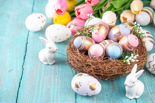 Easter nests and eggs background with spring flowers, Happy Easter holiday greeting card flat lay on wooden background, top view copy space