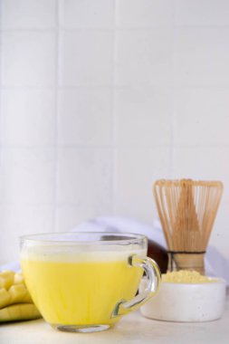Sarı kibrit içeceği. Mango kibrit özü çay ya da latte, beyaz arkaplanda meyveli sağlıklı içecek fotokopi alanı