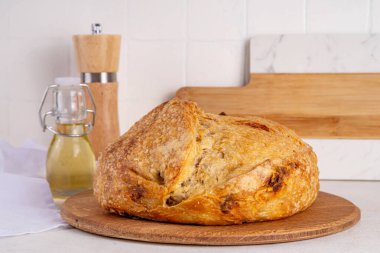 Ev yapımı taze ekşi ekmek. Beyaz bir masada ev yapımı çavdar ekmeği ve beyaz ekmek. Resimdeki kızlar taze kokulu ekmek fotokopi odasını kesiyorlar.