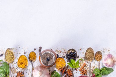 Beyaz arka planda yemek pişirmek için baharatlar. Farklı baharatlar, baharatlar ve otlar biber, zerdeçal, tuz, fesleğen, nane, tarçın, sarımsak ve diğer aromatik karışımlar