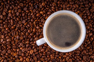 Kruvasan ve kahve çekirdekli sade espresso kahve fincanı, basit geleneksel Fransız kahvaltısı.