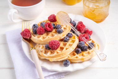 Beyaz ahşap masadaki böğürtlenli ev yapımı Belçika waffle 'ları lezzetli brunch' lar ya da Belçika waffle 'ları.