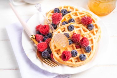 Beyaz ahşap masadaki böğürtlenli ev yapımı Belçika waffle 'ları lezzetli brunch' lar ya da Belçika waffle 'ları.